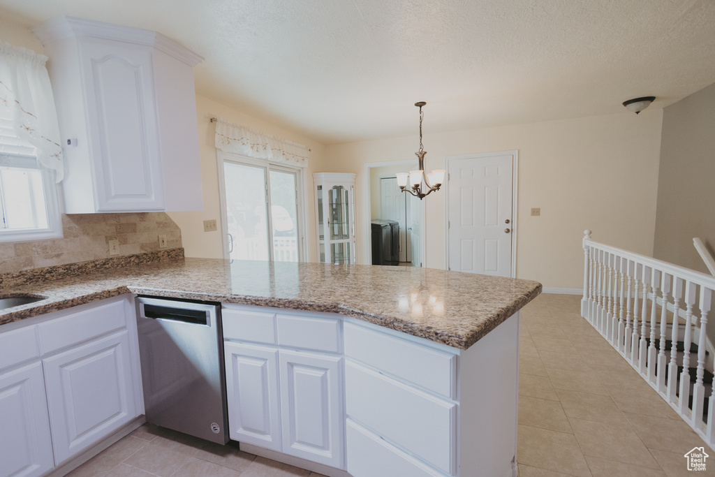 Kitchen with stainless steel dishwasher, a peninsula, healthy amount of natural light, and a chandelier