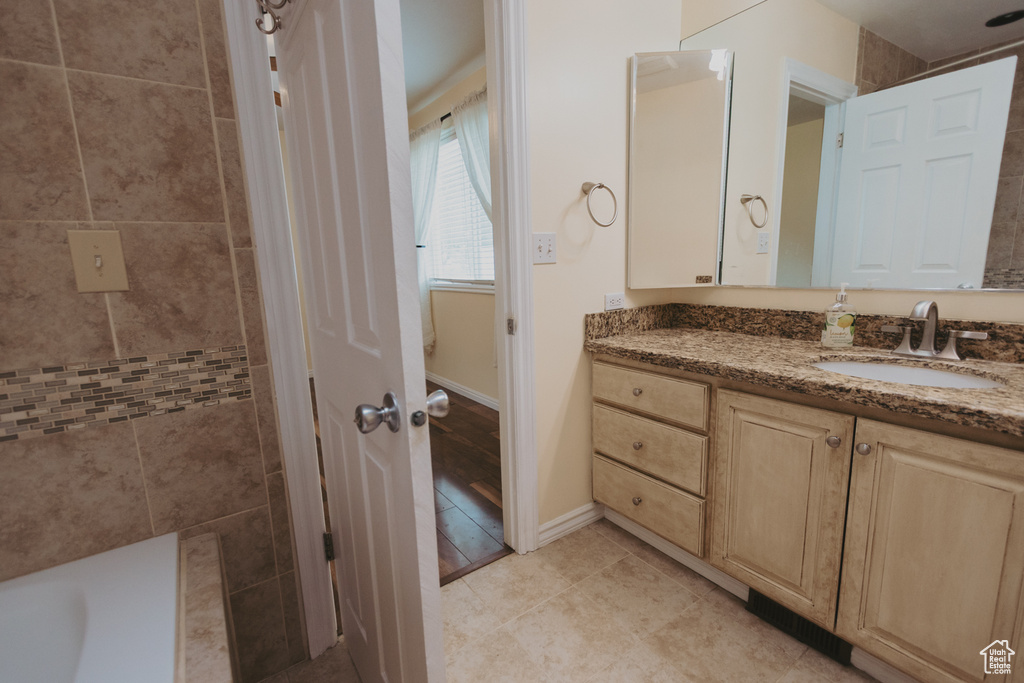 Full bath featuring vanity, baseboards, and tile patterned floors
