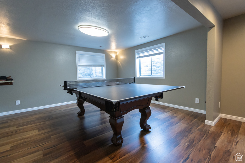 Game room with baseboards, wood finished floors, and a textured ceiling