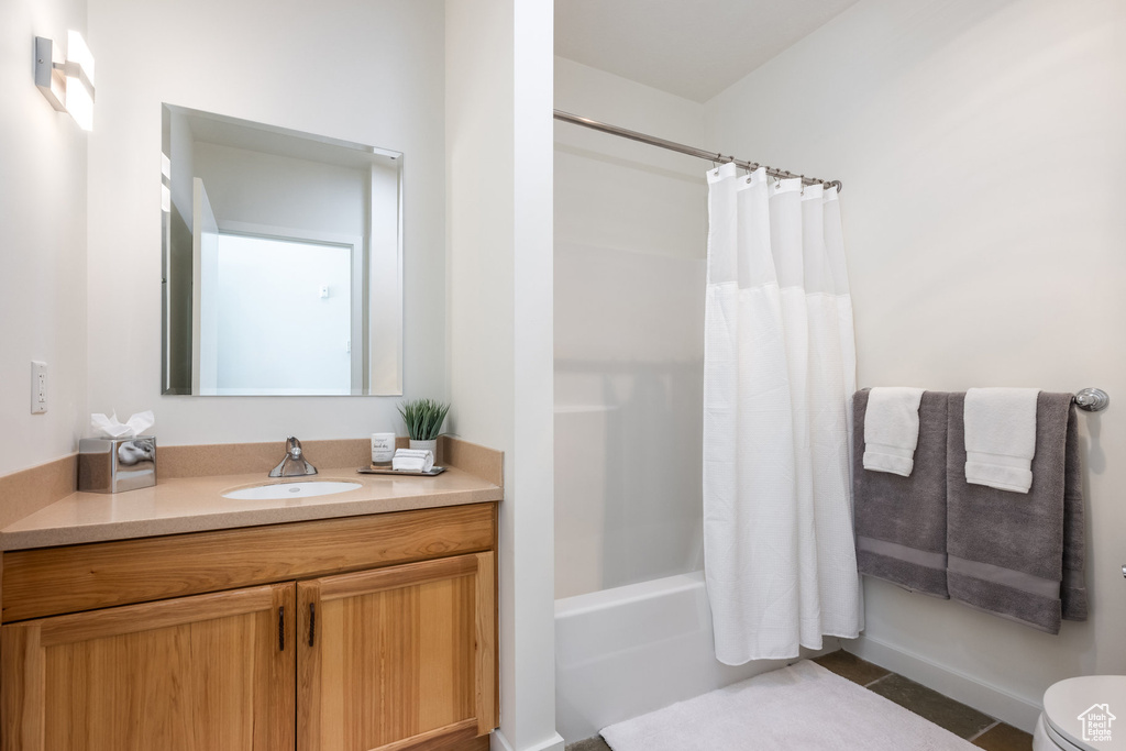 Full bath featuring tile patterned flooring, vanity, shower / tub combo with curtain, and toilet