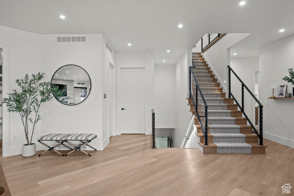 Entrance foyer featuring wood finished floors, recessed lighting, stairs, and baseboards