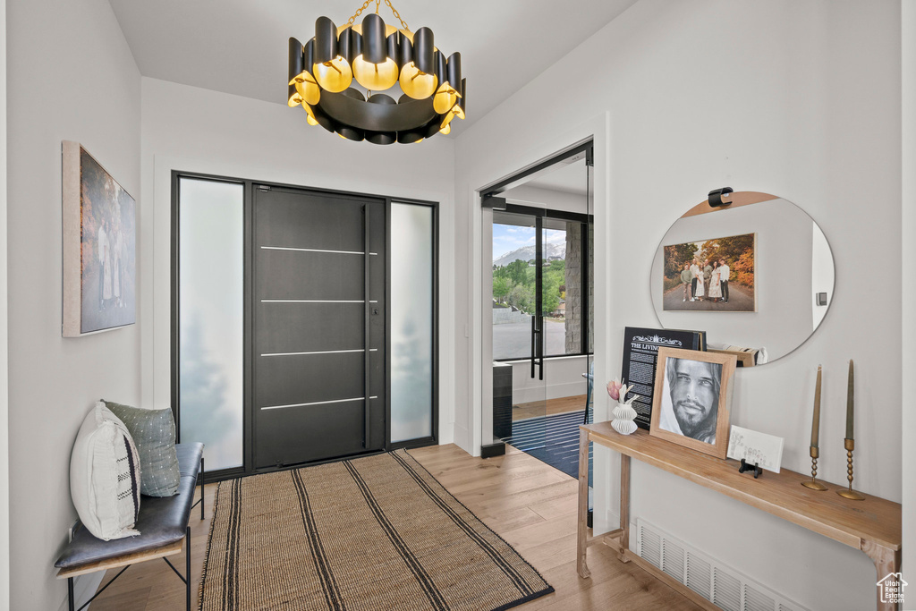 Foyer entrance featuring wood finished floors and a chandelier