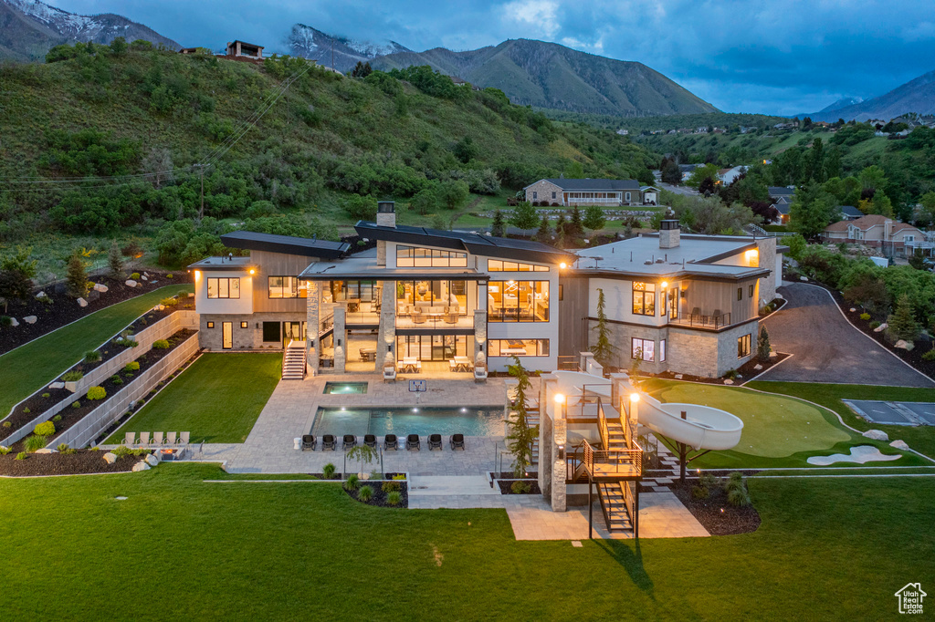 Rear view of house featuring a balcony, stairs, a chimney, and a mountain view