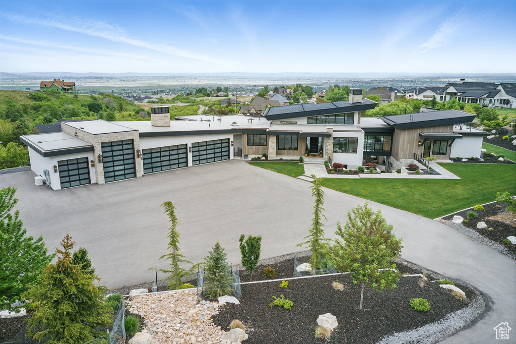Modern home featuring a chimney, a front lawn, and stucco siding
