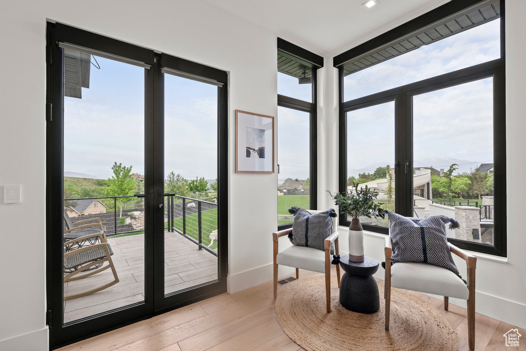 Sitting room featuring healthy amount of natural light, french doors, baseboards, and wood finished floors