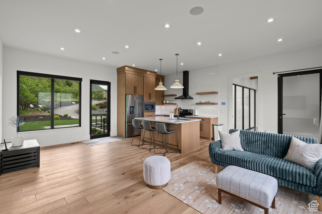 Living area with light wood-style floors and recessed lighting
