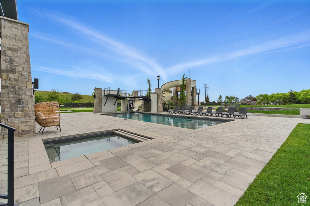 Swimming pool with a patio area and an in-ground hot tub