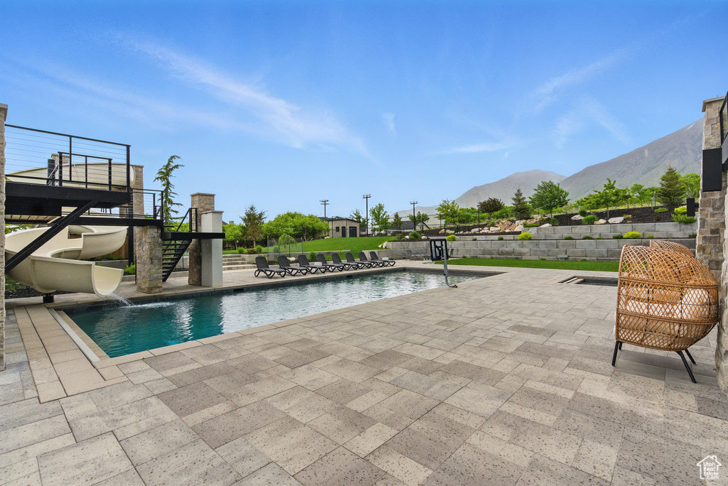 View of swimming pool featuring a patio, stairs, and a mountain view