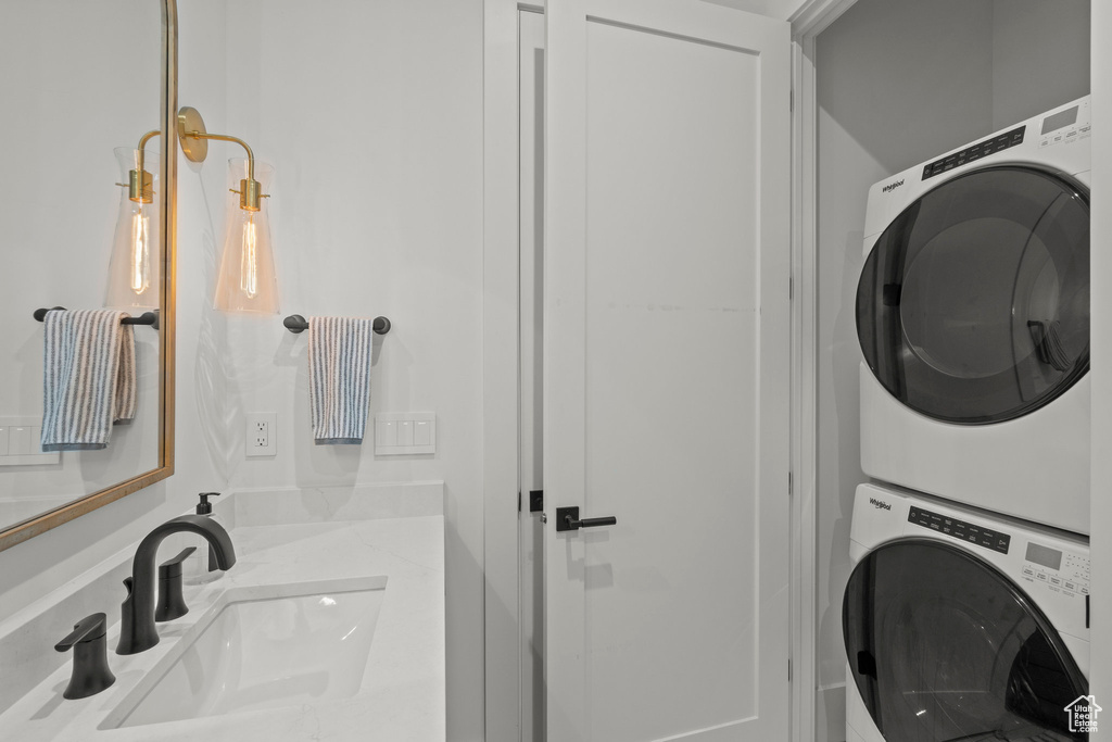 Laundry room featuring stacked washer / dryer and a sink