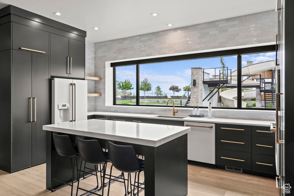 Kitchen with white appliances, healthy amount of natural light, a sink, light countertops, and recessed lighting