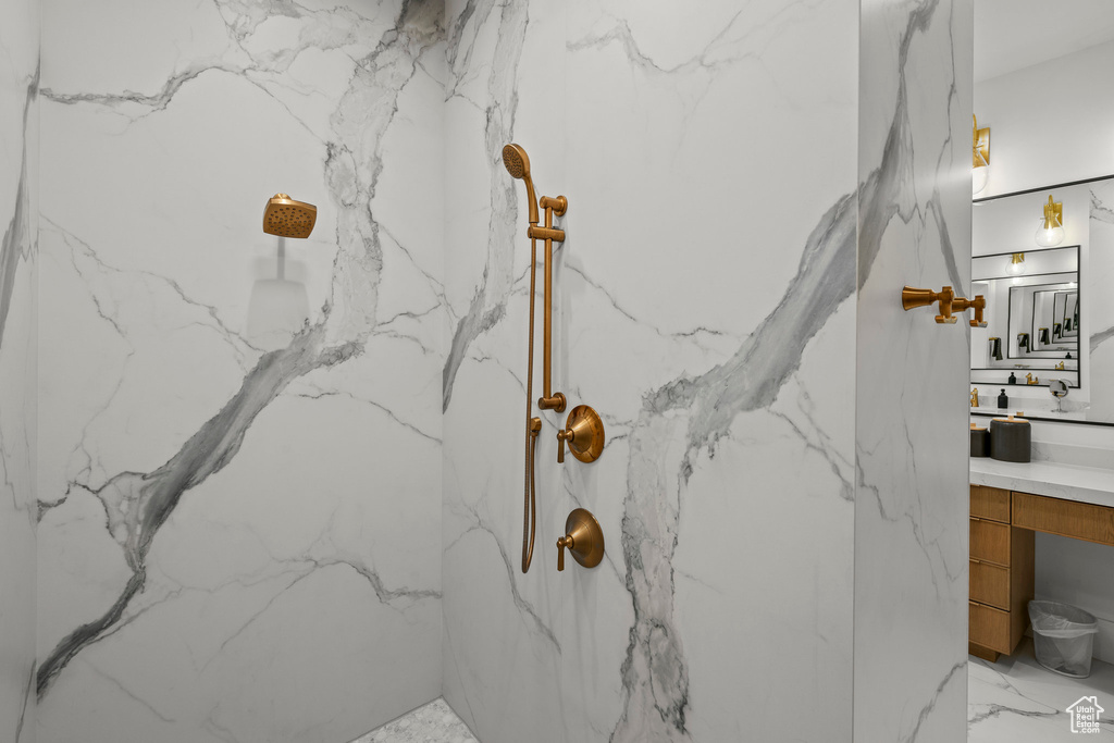 Bathroom view of a marble finish shower and vanity