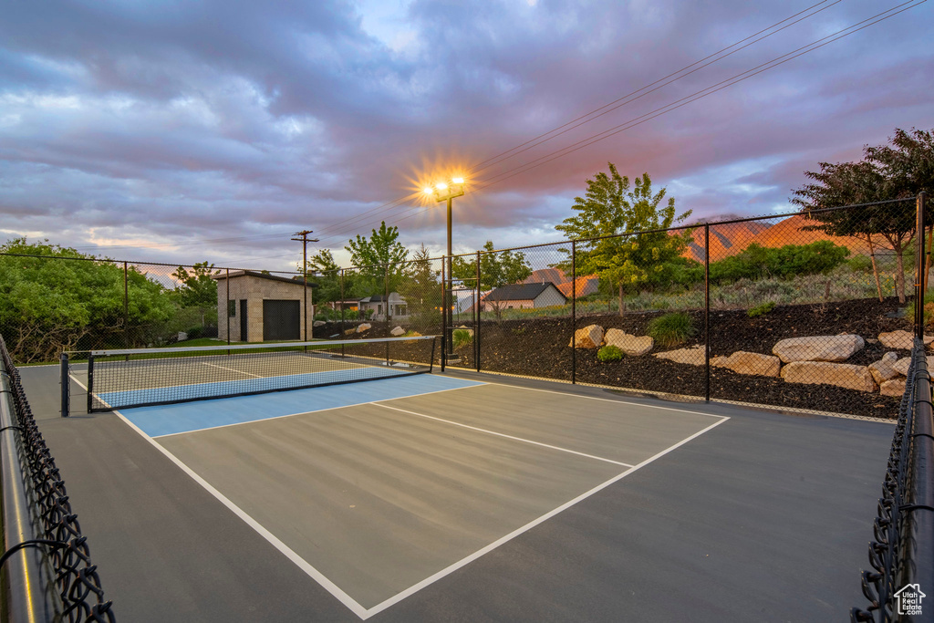 View of tennis court featuring community basketball court and fence