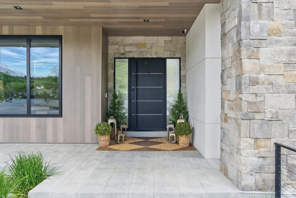 Property entrance with stone siding and a surveillance system