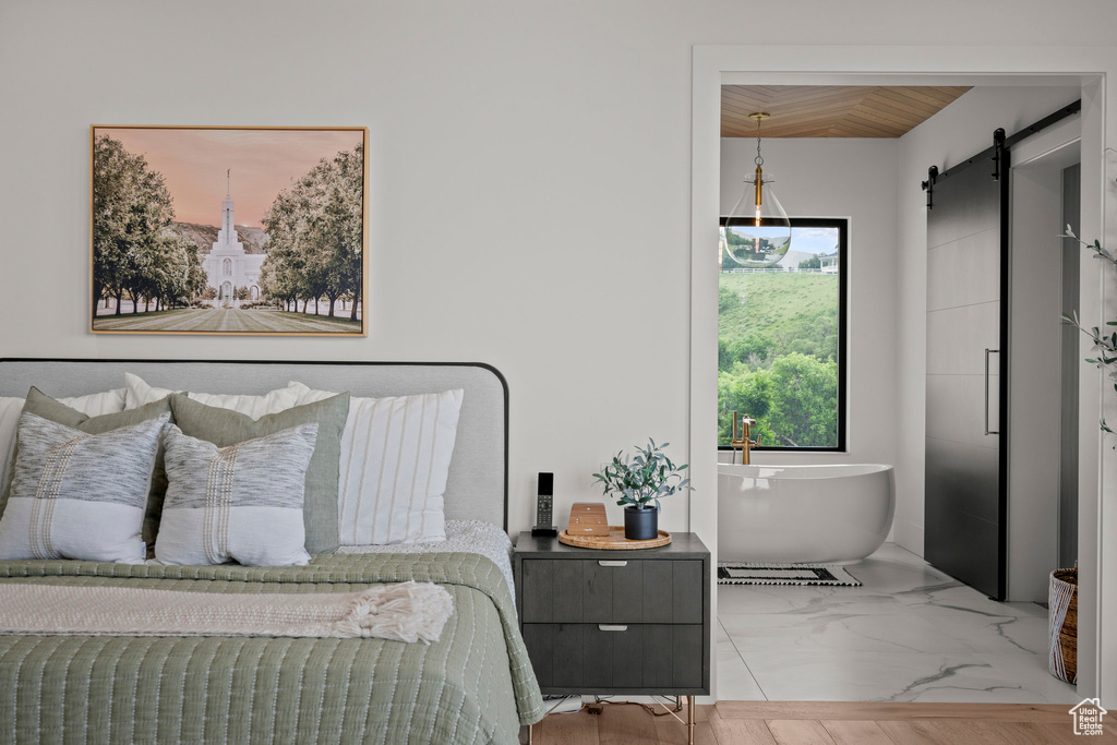 Bedroom featuring a barn door, wooden ceiling, and marble finish floors