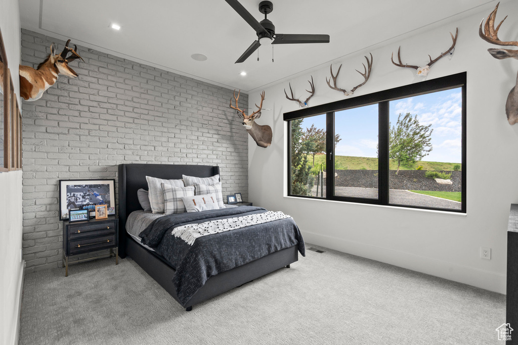 Carpeted bedroom with brick wall, ceiling fan, recessed lighting, ornamental molding, and baseboards