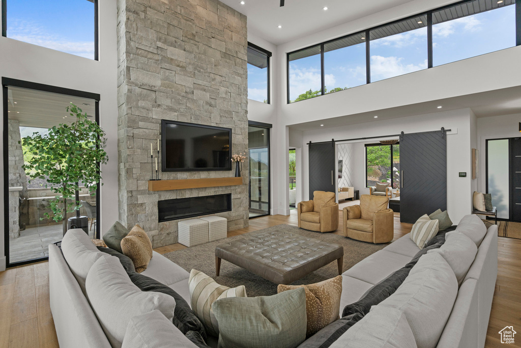 Living room featuring a high ceiling, light wood-style flooring, and a fireplace