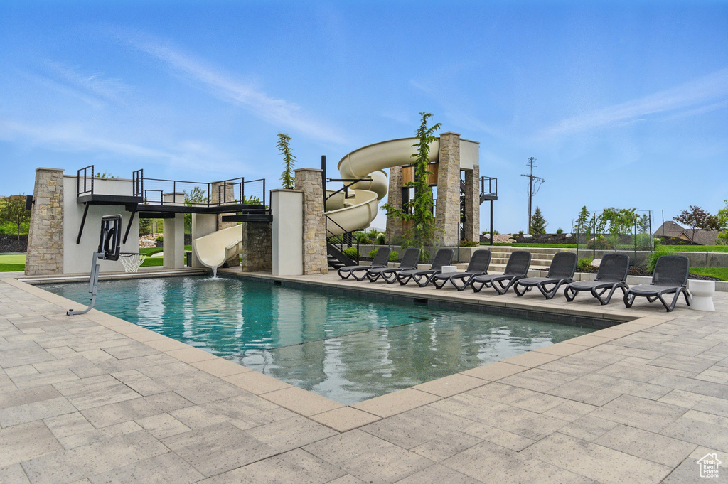 View of swimming pool featuring a water slide and a patio area