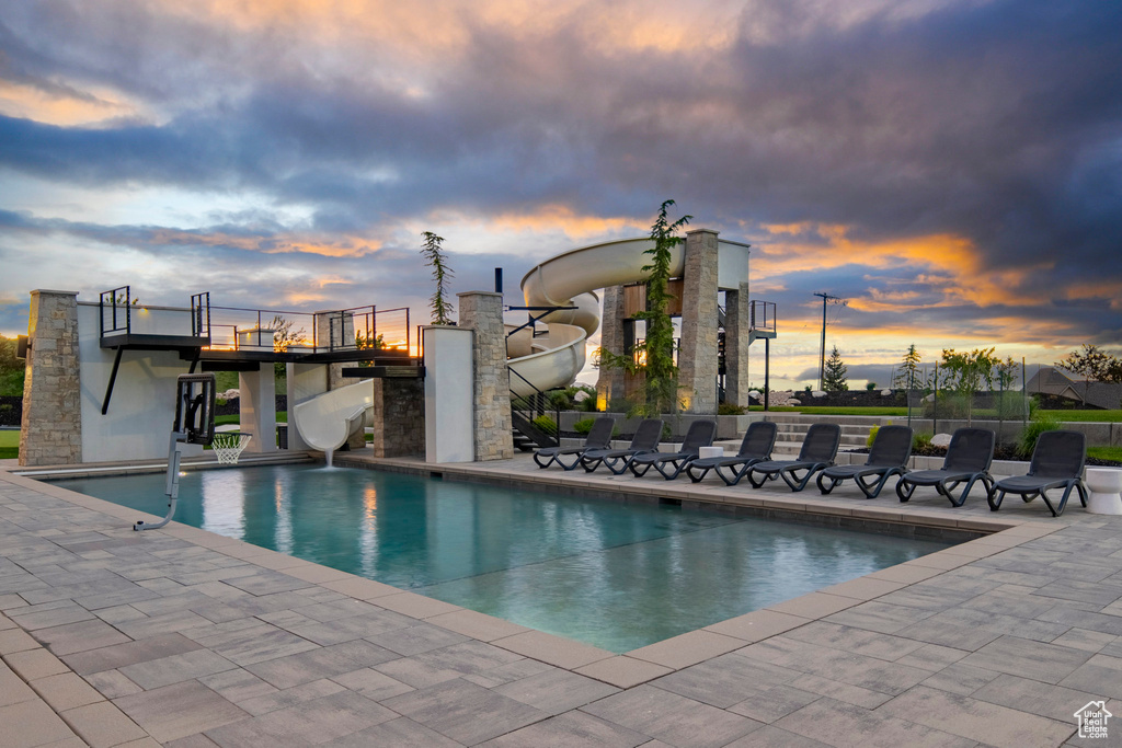Swimming pool with a water slide and a patio area