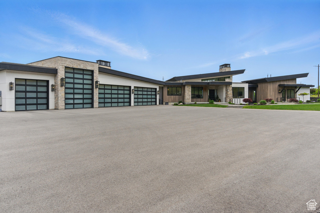 Contemporary home featuring stone siding and driveway