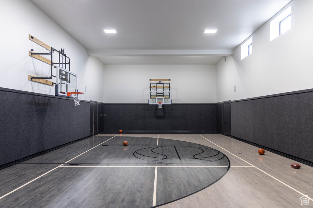 View of basketball court featuring basketball hoop and fence