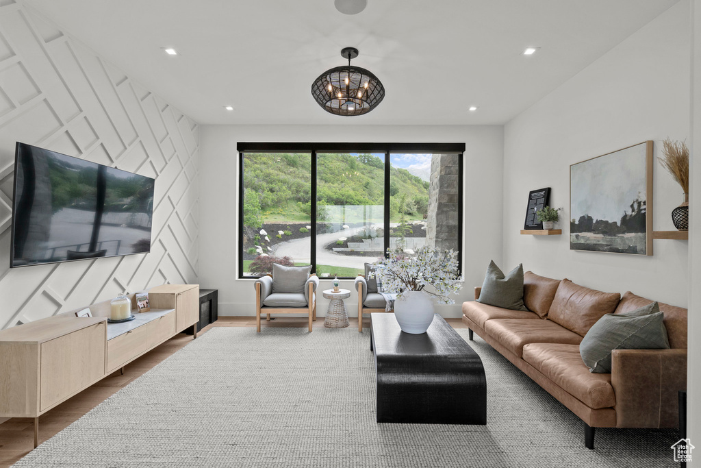 Living area with a chandelier, wood finished floors, and recessed lighting