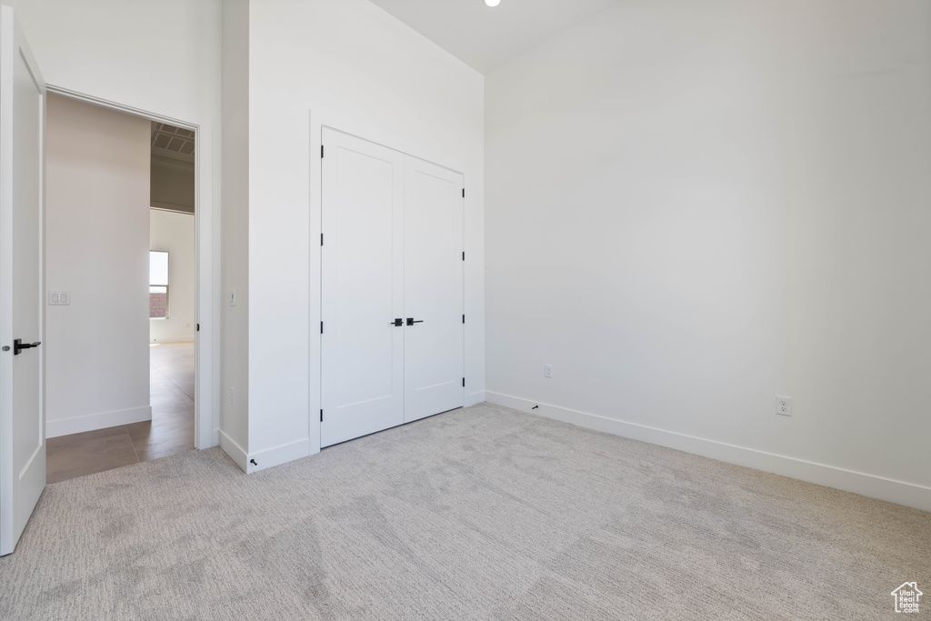 Unfurnished bedroom featuring carpet, a closet, and baseboards