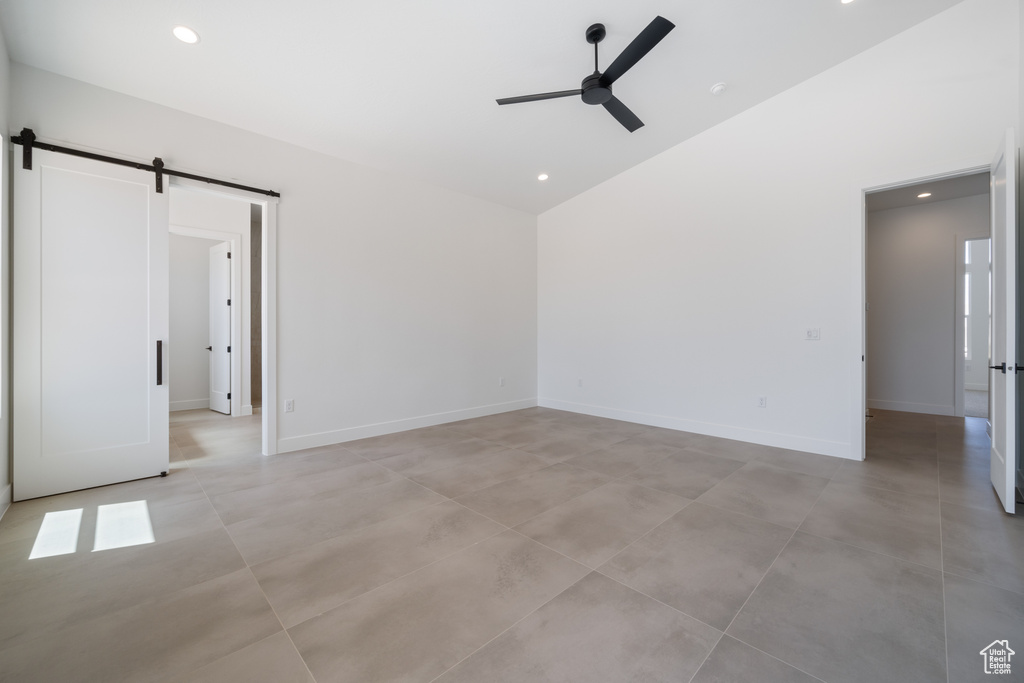 Unfurnished room with a ceiling fan, a barn door, baseboards, high vaulted ceiling, and recessed lighting
