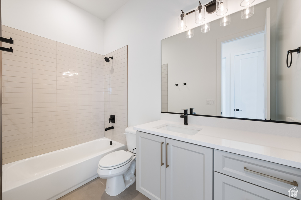 Bathroom featuring toilet, vanity, washtub / shower combination, and tile patterned floors
