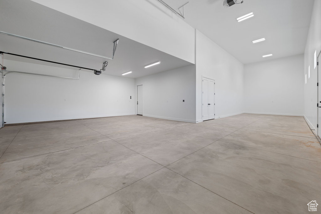 Garage with a garage door opener and baseboards