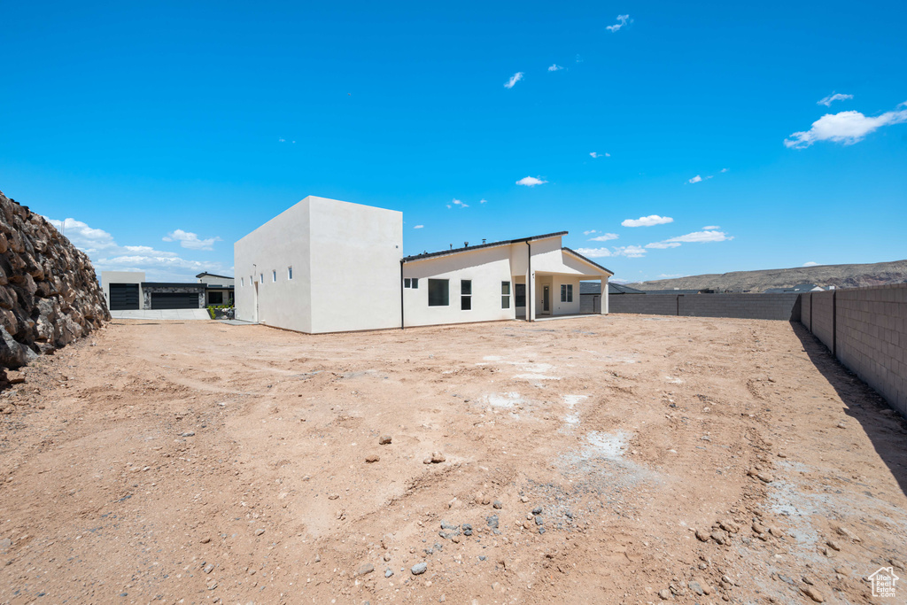 Rear view of property with stucco siding and a fenced backyard