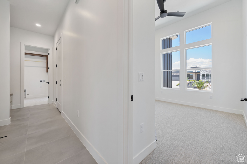 Hallway featuring baseboards, plenty of natural light, and recessed lighting