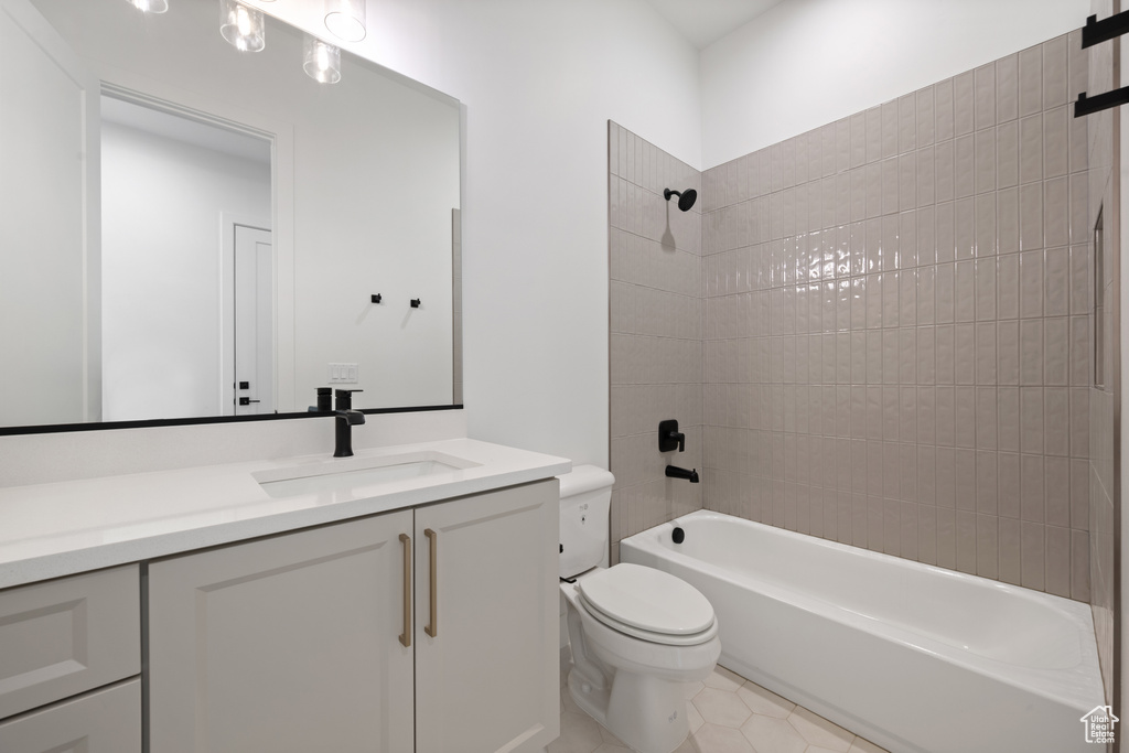 Bathroom with toilet, vanity, bathing tub / shower combination, and tile patterned flooring