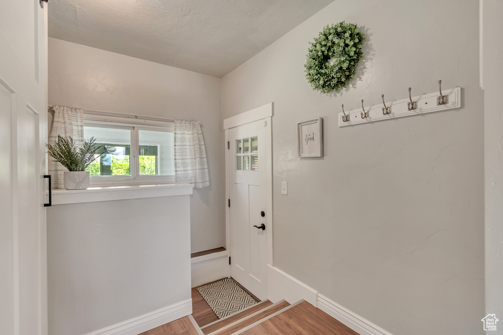 Doorway featuring wood finished floors and baseboards