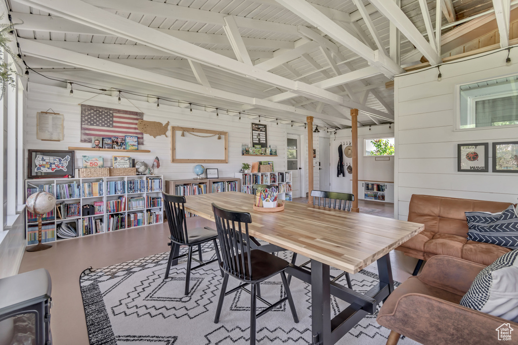 Dining space featuring wooden walls and vaulted ceiling