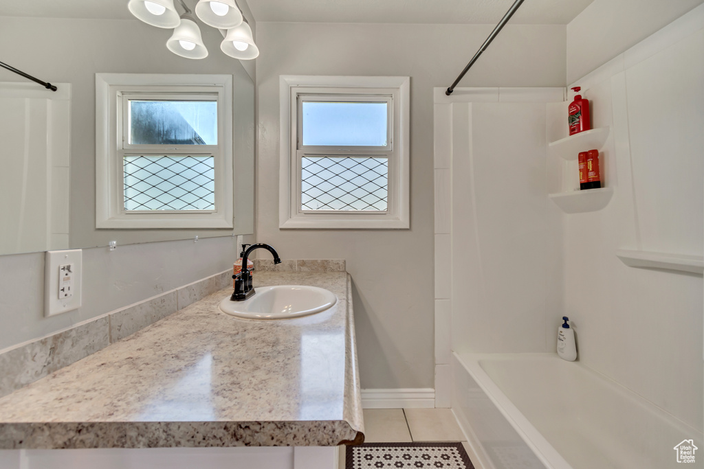 Full bathroom with tile patterned floors, tub / shower combination, and vanity