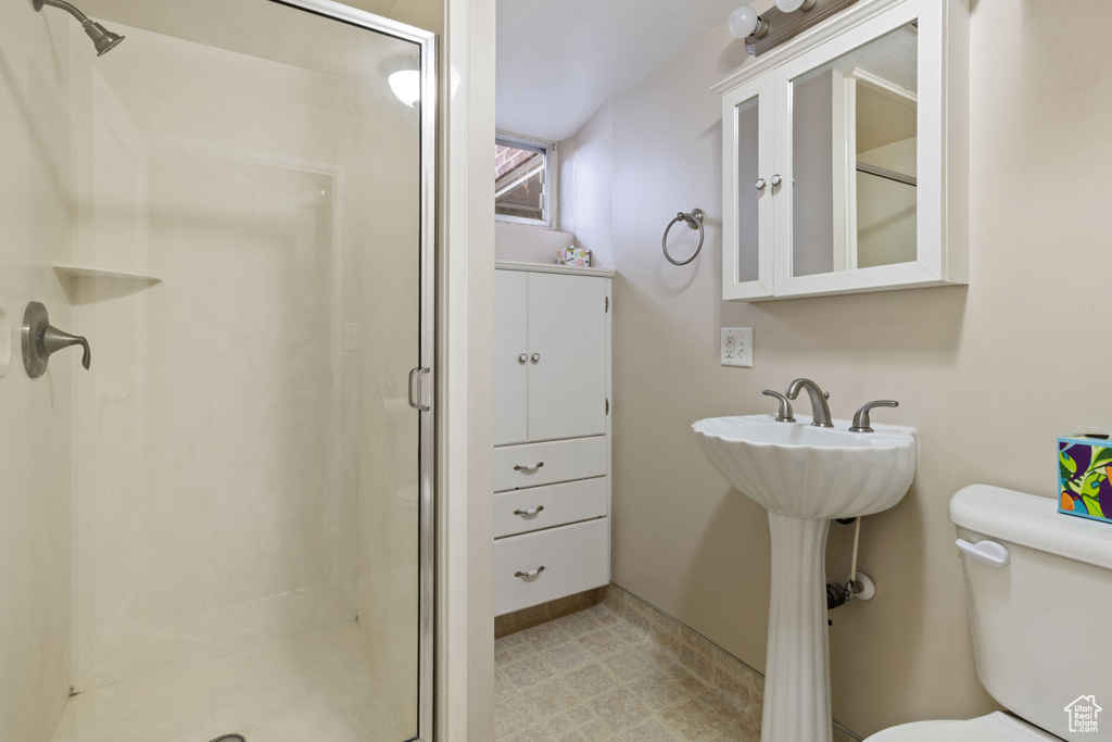 Full bath with a shower stall, toilet, and baseboards