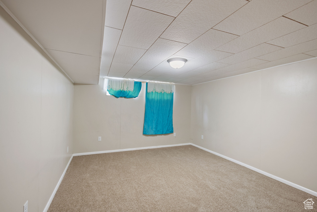 Carpeted spare room featuring baseboards