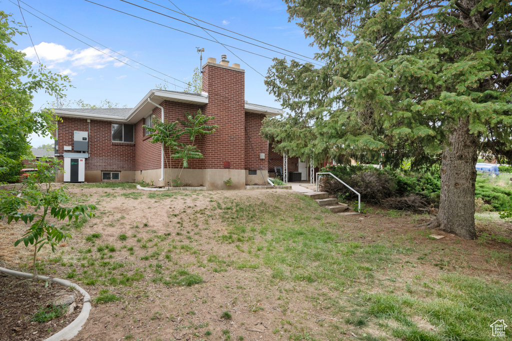 Rear view of house with brick siding and a chimney