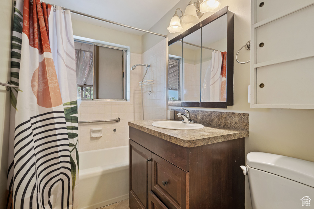 Full bathroom with vanity, shower / bathtub combination with curtain, and toilet