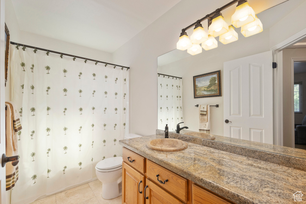 Full bath with tile patterned flooring, vanity, toilet, and a shower with shower curtain