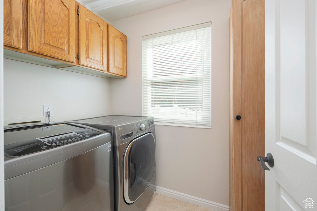 Laundry area with separate washer and dryer, cabinet space, and baseboards