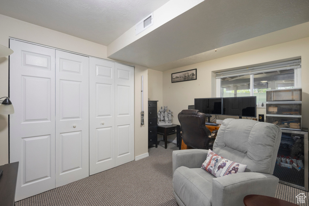 Carpeted office space with beverage cooler and baseboards