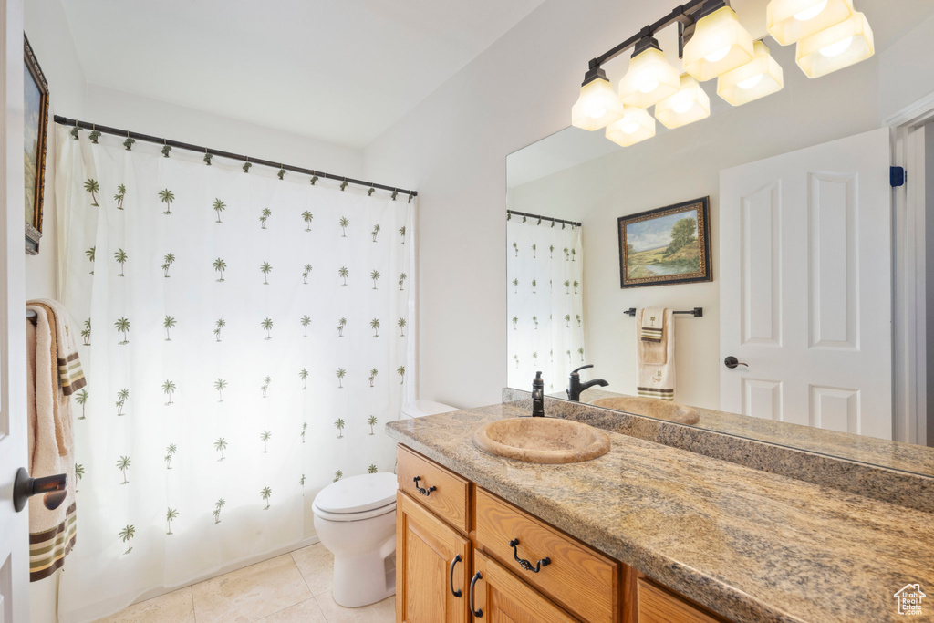 Bathroom featuring toilet, vanity, and tile patterned flooring