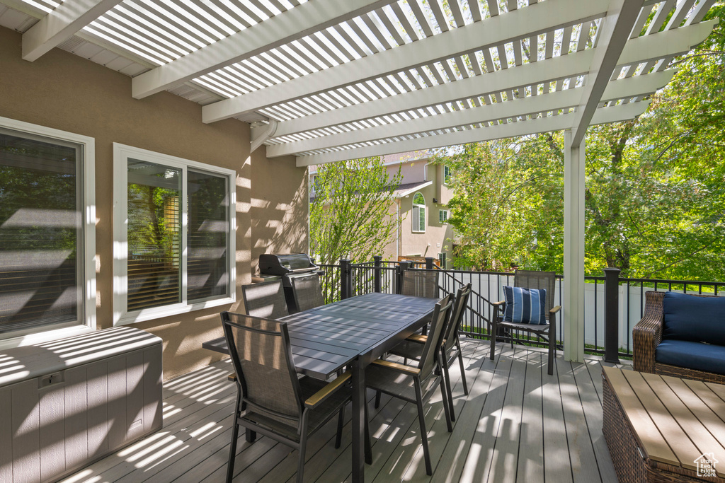 Wooden deck with a pergola, outdoor dining area, and grilling area