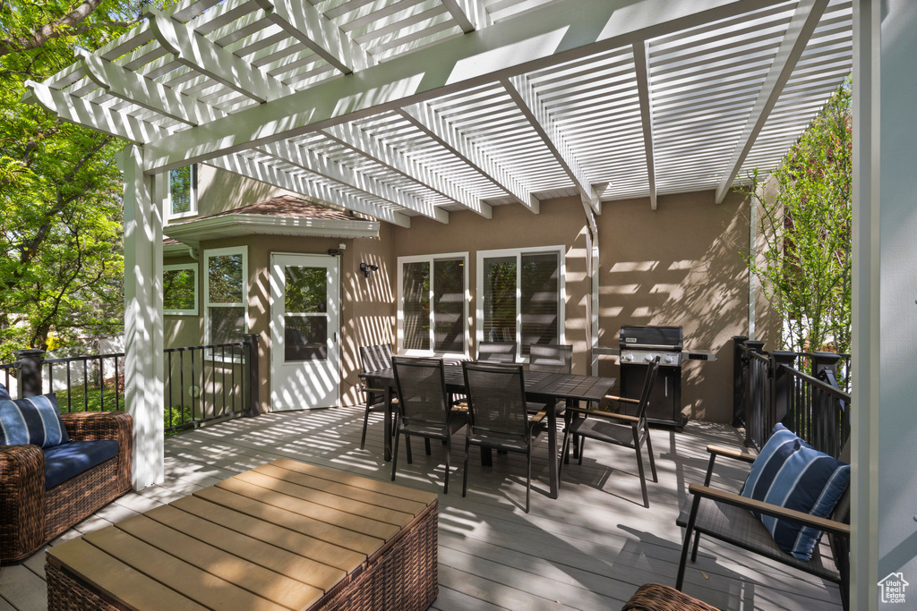 Wooden terrace with grilling area, a pergola, and outdoor dining space