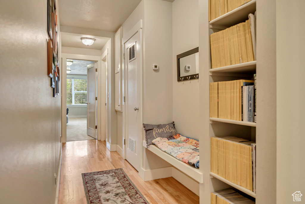 Hall with light wood finished floors and baseboards