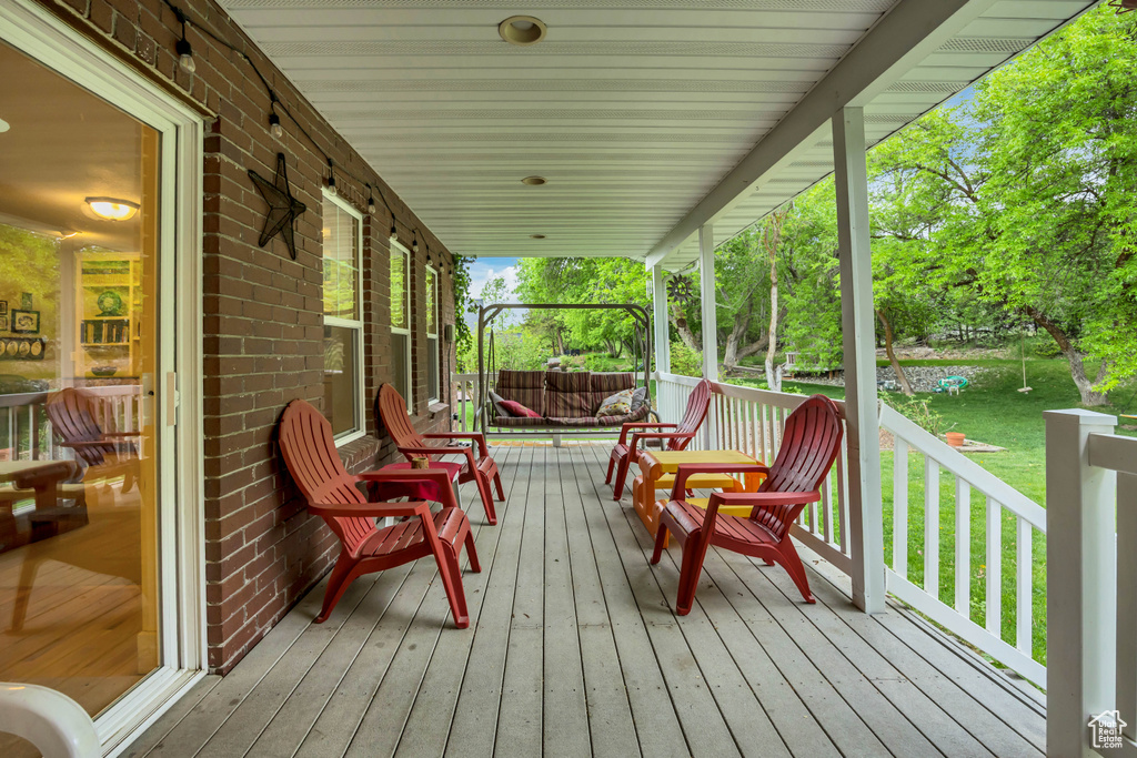 Wooden deck featuring a porch and a lawn
