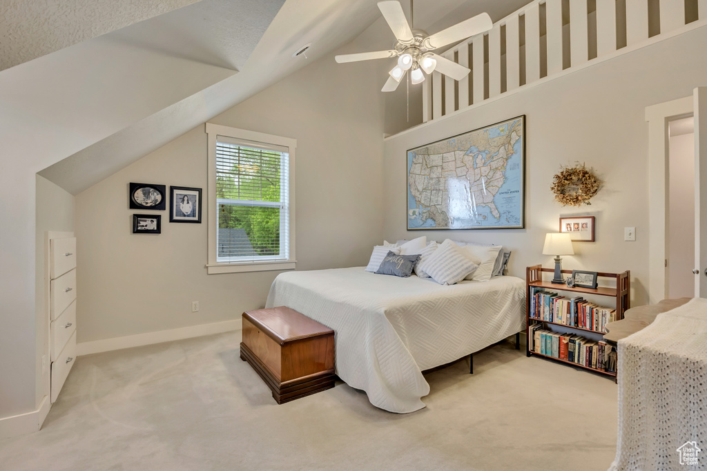 Carpeted bedroom featuring baseboards, ceiling fan, and high vaulted ceiling