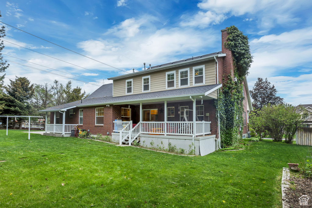 View of front of house with a porch, a chimney, and brick siding