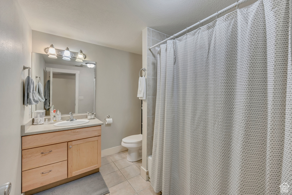 Full bathroom featuring tile patterned flooring, vanity, toilet, and a shower with shower curtain